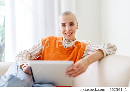 Beautiful woman freelancer with very short hair working at tablet at home Beautiful woman freelancer with very short hair working at tablet at home 96256141