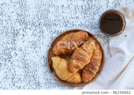 A cup of coffee and croissant on white table. A cup of coffee and croissant on white table. 96256662