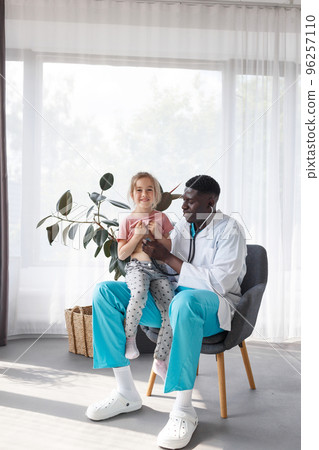 an African-American doctor examines a child with a stethoscope. an African-American doctor examines a child with a stethoscope. 96257110