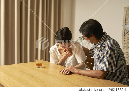 Middle-aged woman with chest pain in the living room at night 96257824