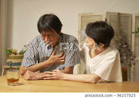 Middle-aged man with chest pain in the living room at night 96257825