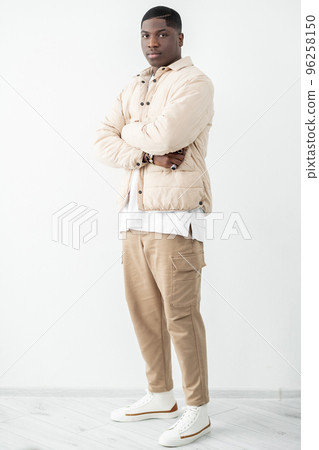 Confident man portrait. Trendy guy in beige outfit standing in studio Confident man portrait. Trendy guy in beige outfit standing in studio 96258150