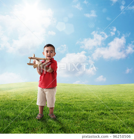 Dreaming trips of a kid on a green field 96258506