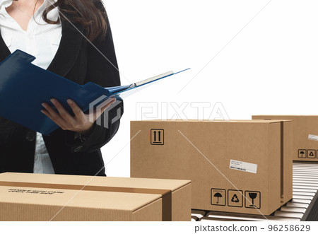 Businesswoman checks boxes on conveyor roller Businesswoman checks boxes on conveyor roller 96258629