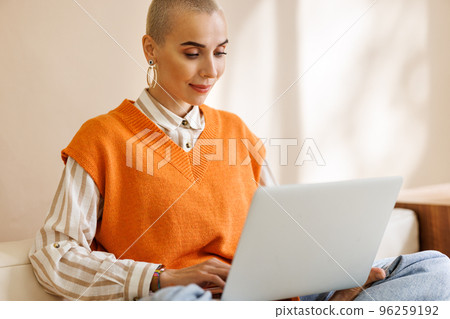Beautiful woman freelancer with very short hair working at laptop at home Beautiful woman freelancer with very short hair working at laptop at home 96259192