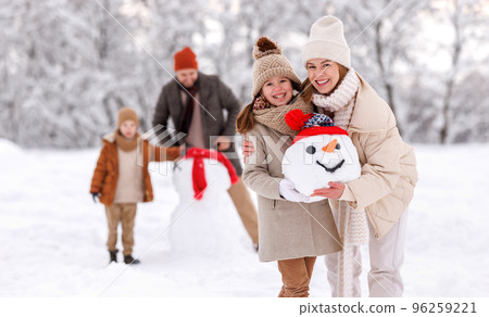 Cheerful family parents with kids in snowy winter park have fun and actively relax outdoors Cheerful family parents with kids in snowy winter park have fun and actively relax outdoors 96259221