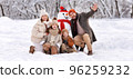 Happy family in warm clothes laughing merrily while making snowman together 96259232