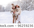 Happy mother embracing little girl daughter while having fun in snowy weather outdoor 96259236
