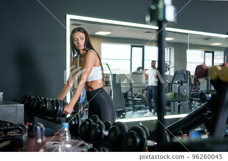 sporty young woman choosing dumbbells for training. sporty young woman choosing dumbbells for training. 96260045