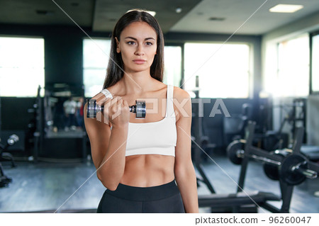 sporty woman performing an exercise with a kettlebell . 96260047