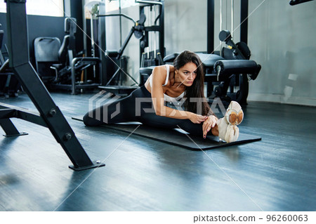 sporty woman doing stretching on a sports mat. 96260063