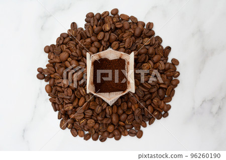 Drip pack stands on roasted coffee beans. The concept of delicious and convenient coffee preparation. Top view. 96260190