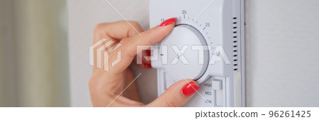 Female hand adjusting temperature of air conditioner with roller closeup Female hand adjusting temperature of air conditioner with roller closeup 96261425