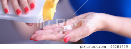 Woman pouring moisturizing body lotion from bottle on hand closeup 96261439