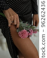 A girl holds flowers near her feet 96262436
