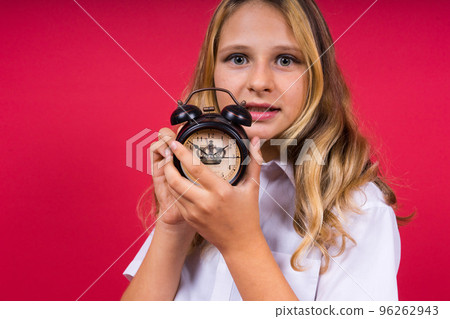 Young Girl holding an antique clock over red background 96262943