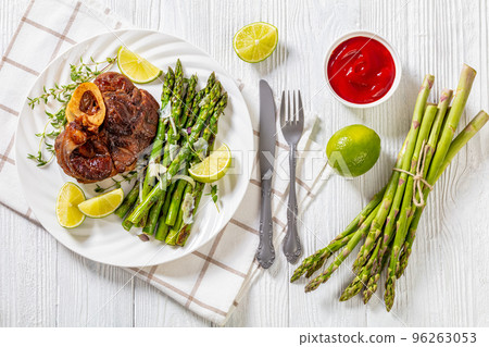 braised osso buco with grilled asparagus, top view 96263053