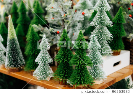 Various decorative artificial small Christmas trees in the store on the Christmas market. Preparing for winter holidays. Happy New year background. Selective focus. Various decorative artificial small Christmas trees in the store on the Christmas market. Preparing for winter holidays. Happy New year background. Selective focus. 96263983