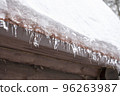 Close-up of melting snow icicles on roof. 96263987