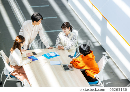 Male and female college students having a meeting in a classroom Male and female college students having a meeting in a classroom 96265186