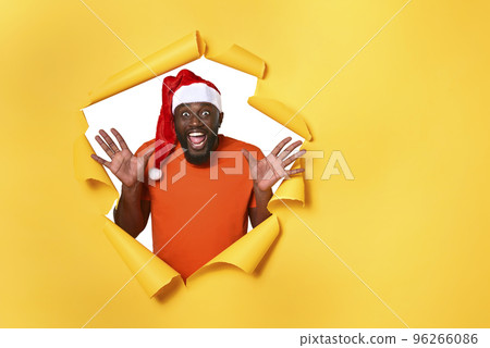 Afro man with hat is happy because is Christmas. Yellow background 96266086