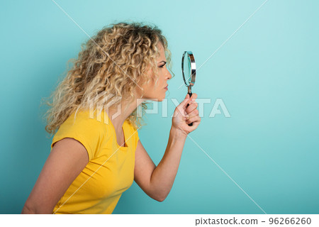 Girl is distrustful and has doubt about something. Cyan background Girl is distrustful and has doubt about something. Cyan background 96266260