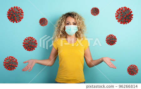Blonde girl has doubt about covid19 corona virus. Cyan background Blonde girl has doubt about covid19 corona virus. Cyan background 96266814