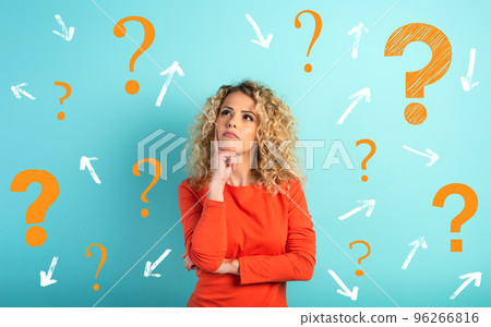 Confused and pensive expression of a girl with many questions . cyan colored background 96266816