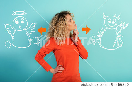Girl is undecided between the advice of the devil and those of the angel. cyan background 96266820