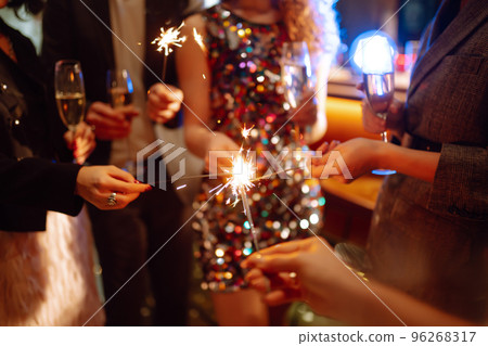 Sparkling sparklers in the hands. Playing firework to celebrate winter holidays with friends at party. 96268317