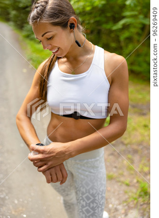 Well trained woman using fitness smart watch device under workout Well trained woman using fitness smart watch device under workout 96269409