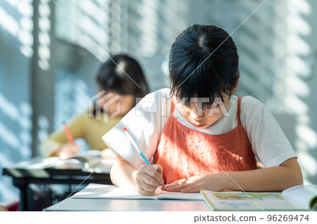 Elementary school students studying in the classroom. 96269474