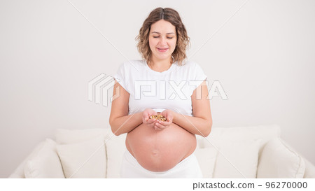 Pregnant woman holding a handful of walnuts. Pregnant woman holding a handful of walnuts. 96270000