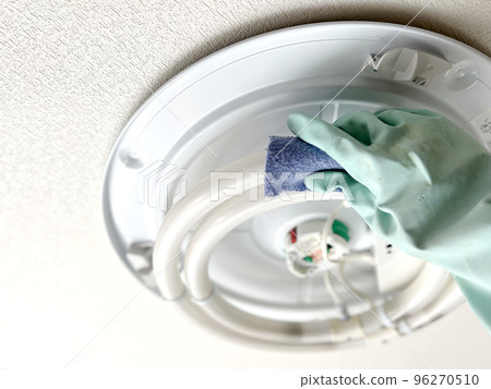 A hand with vinyl gloves wiping the round fluorescent lamp on the ceiling A hand with vinyl gloves wiping the round fluorescent lamp on the ceiling 96270510