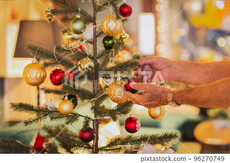 Senior man decorating a Christmas tree at home. Senior man decorating a Christmas tree at home. 96270749