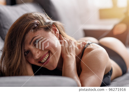 Happy woman relaxing in lingerie on a sofa 96271916