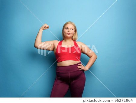Fat girl does gym at home. thoughtful expression. Cyan background Fat girl does gym at home. thoughtful expression. Cyan background 96271964
