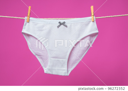Female panties hanging on rope against pink studio background Female panties hanging on rope against pink studio background 96272352