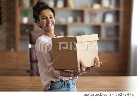 Happy young woman holding box parcel and smiling Happy young woman holding box parcel and smiling 96272476
