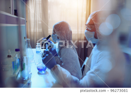 Doctor in the laboratory analyzes samples under a microscope. Pharmaceutical treatment concept. 96273081
