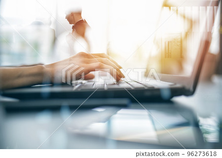 Close-up on the hands of a woman typing on a laptop keyboard. Smart working concept with double exposure effects 96273618