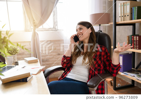 Woman teleworker works at home with a laptop and smartphone 96273809