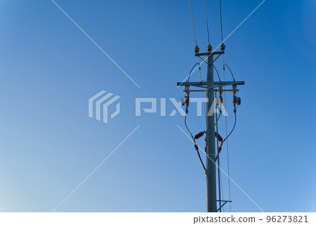 electric power sky lines and connections on a wooden post. wooden electricity post against blue sky. Electric power lines and wires with blue sky. 96273821