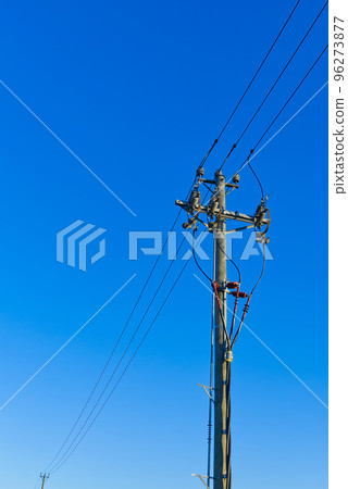 electric power sky lines and connections on a wooden post. wooden electricity post against blue sky. Electric power lines and wires with blue sky. 96273877