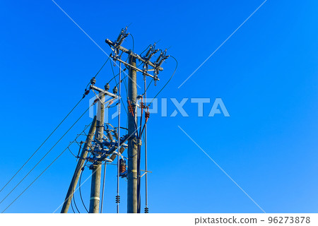 electric power sky lines and connections on a wooden post. wooden electricity post against blue sky. Electric power lines and wires with blue sky. electric power sky lines and connections on a wooden post. wooden electricity post against blue sky. Electric power lines and wires with blue sky. 96273878