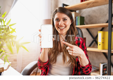 Girl does a video call with her family, due to covid19 coronavirus. White space on smartphone for your text 96274422