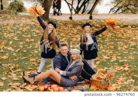 A big family on a picnic in the fall in a nature park. Happy people in the autumn park 96274760