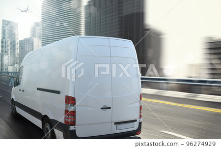 White van moving fast on the highway with a modern city in the background 96274929