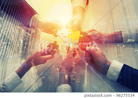 Teamwork of partners. Concept of integration and startup with puzzle pieces. double exposure Teamwork of partners. Concept of integration and startup with puzzle pieces. double exposure 96275534