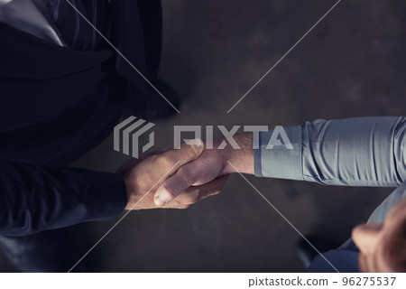 Handshaking business person in office. concept of teamwork and partnership Handshaking business person in office. concept of teamwork and partnership 96275537